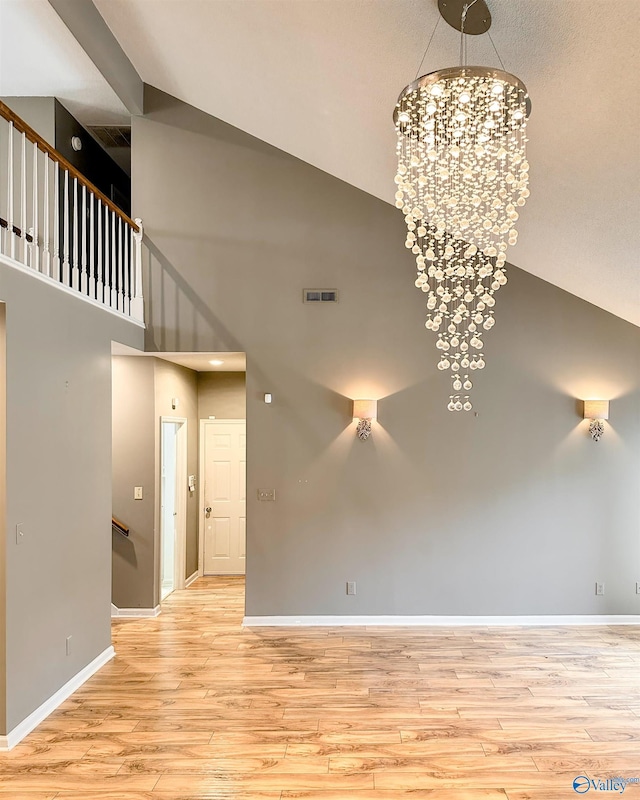 1509 Southampton Ct, Decatur, AL 35601 - spare room featuring high vaulted ceiling, a chandelier, wood finished floors, and baseboards