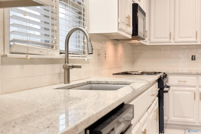 1509 Southampton Ct, Decatur, AL 35601 - kitchen with electric stove, white cabinets, a sink, tasteful backsplash, and black microwave