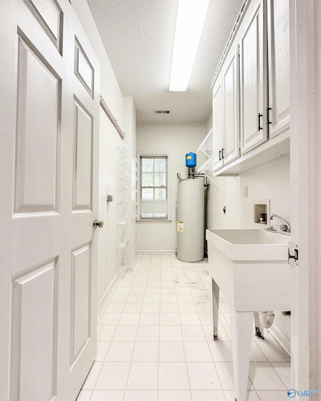 1509 Southampton Ct, Decatur, AL 35601 - washroom with water heater, cabinet space, washer hookup, a textured ceiling, and electric dryer hookup