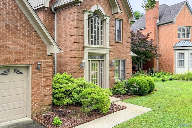 1509 Southampton Ct, Decatur, AL 35601 - view of exterior entry with brick siding, a yard, and a garage