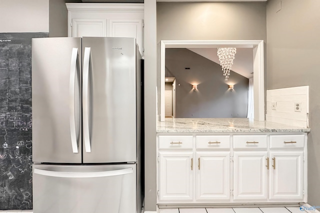 1509 Southampton Ct, Decatur, AL 35601 - kitchen featuring freestanding refrigerator, light stone countertops, white cabinetry, and a chandelier
