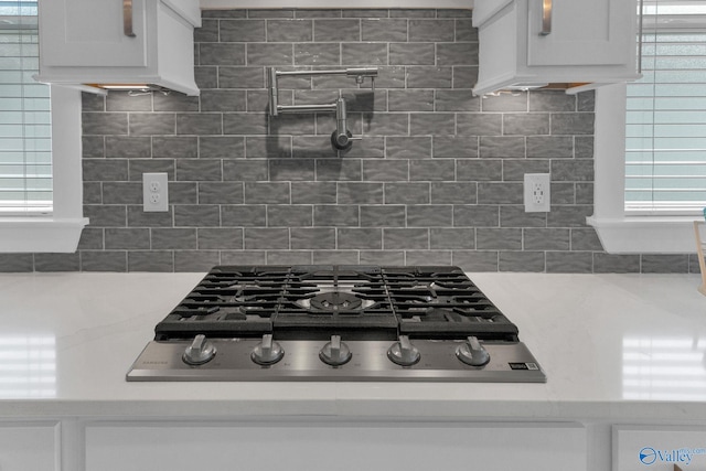 241 Farmhouse Dr, Madison, AL 35757 - kitchen view of pot filler, gas stovetop, light countertops, and white cabinets