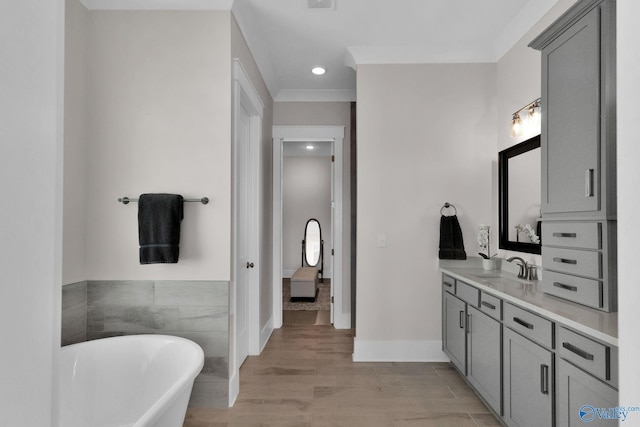 241 Farmhouse Dr, Madison, AL 35757 - bathroom with a freestanding bath, vanity, wood finished floors, recessed lighting, and ornamental molding