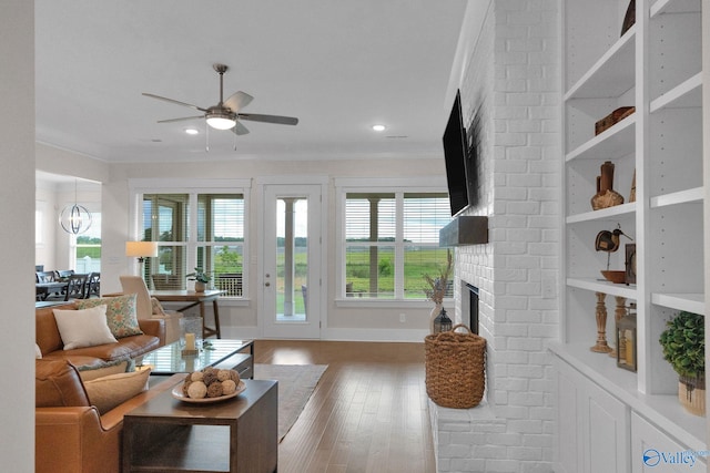 241 Farmhouse Dr, Madison, AL 35757 - living room with a fireplace, plenty of natural light, a ceiling fan, wood finished floors, and ornamental molding
