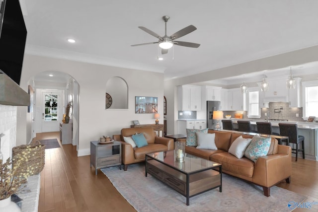 241 Farmhouse Dr, Madison, AL 35757 - living room with a ceiling fan, light wood-type flooring, baseboards, ornamental molding, and arched walkways