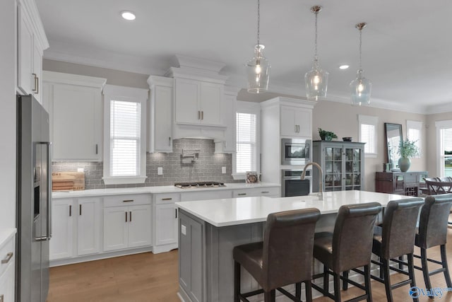 241 Farmhouse Dr, Madison, AL 35757 - kitchen with stainless steel appliances, crown molding, light countertops, tasteful backsplash, and a breakfast bar