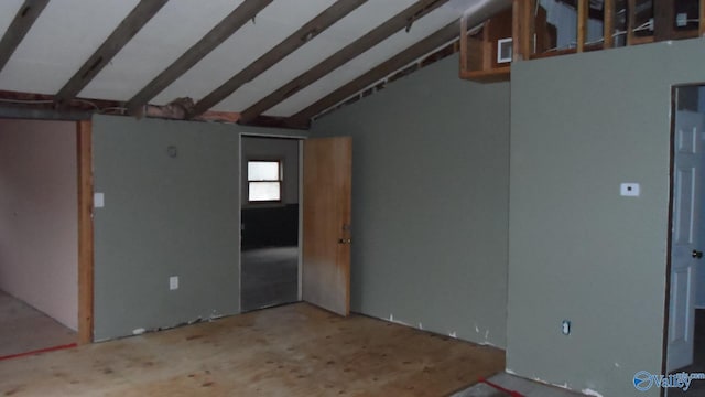 unfurnished room with visible vents and vaulted ceiling with beams