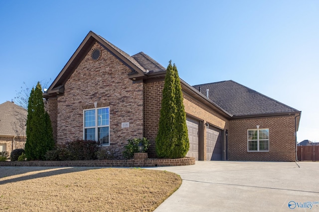 108 NW Rockhaven Dr, Madison, AL 35757 - view of front of house with an attached garage, brick siding, concrete driveway, and a shingled roof