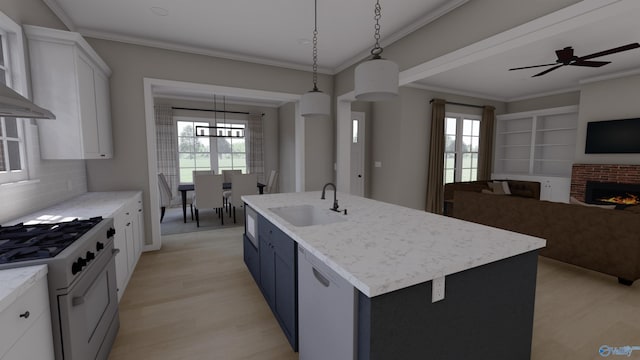 kitchen with a kitchen island with sink, white dishwasher, sink, gas range oven, and white cabinetry