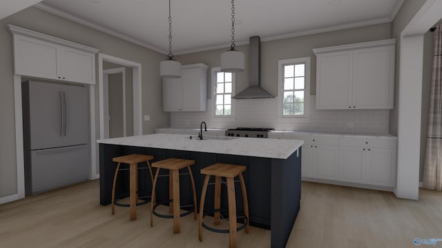 kitchen featuring wall chimney exhaust hood, white fridge, white cabinetry, and a kitchen island with sink