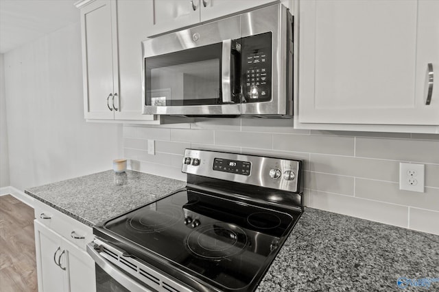 kitchen featuring tasteful backsplash, stone countertops, appliances with stainless steel finishes, and white cabinetry