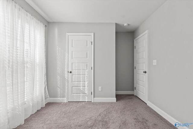 unfurnished bedroom with baseboards and carpet flooring