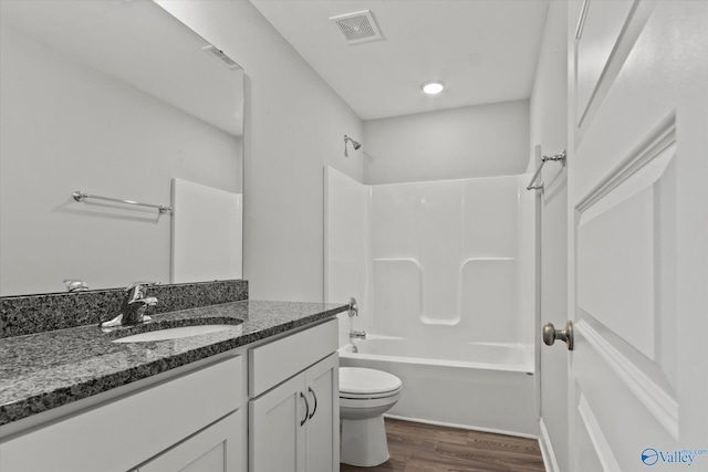 bathroom featuring wood finished floors, vanity, washtub / shower combination, toilet, and visible vents