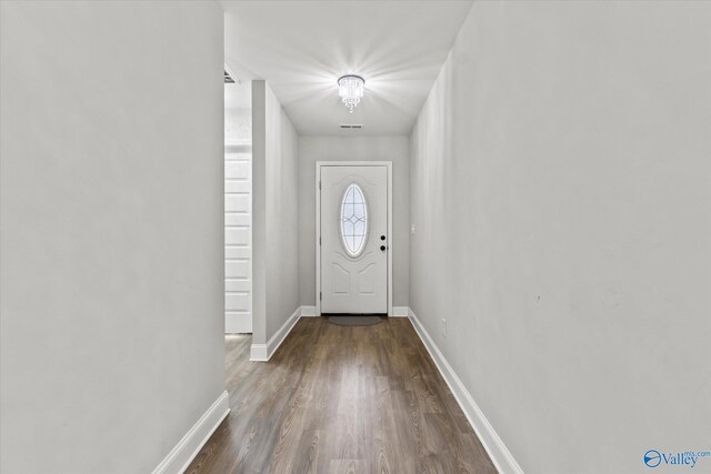 entryway featuring baseboards, dark wood-type flooring, and visible vents