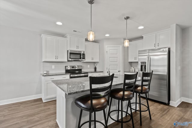 kitchen with stainless steel appliances, baseboards, visible vents, and white cabinetry