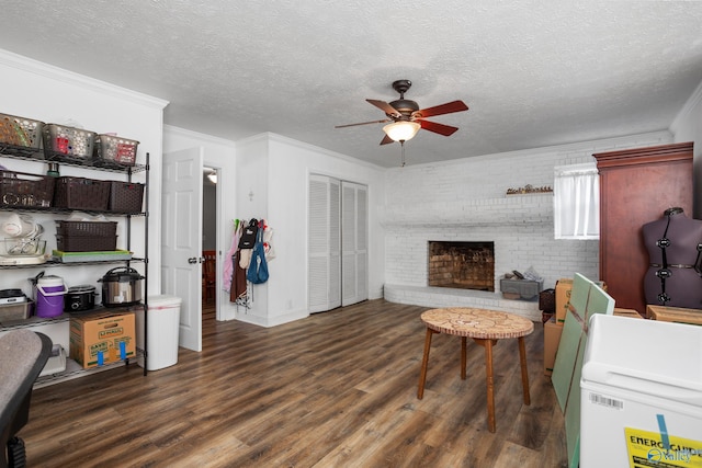 living room featuring a fireplace, ornamental molding, a textured ceiling, and dark hardwood / wood-style flooring