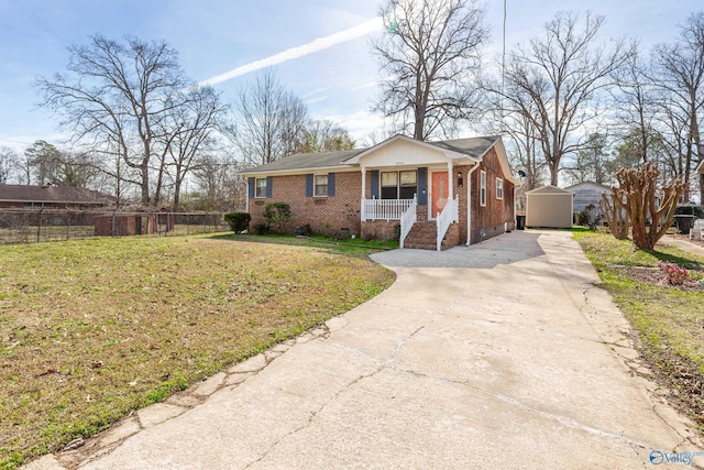 view of front of property featuring covered porch, a shed, and a front lawn