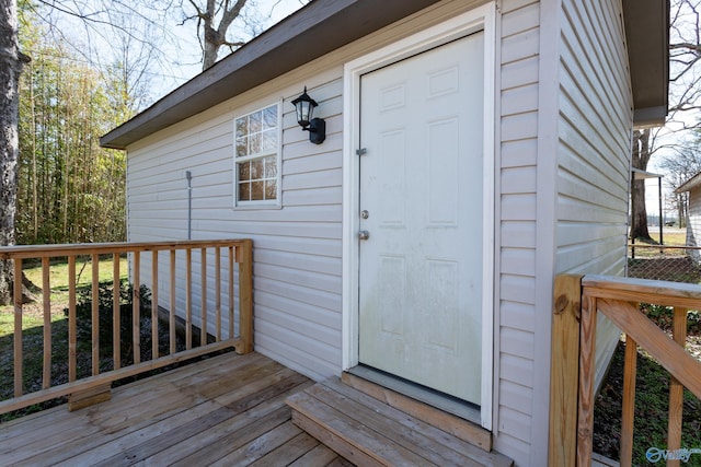 view of exterior entry featuring a wooden deck