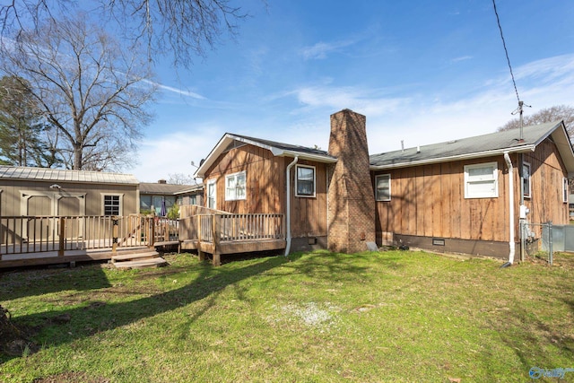 back of house with a yard, a wooden deck, and a shed