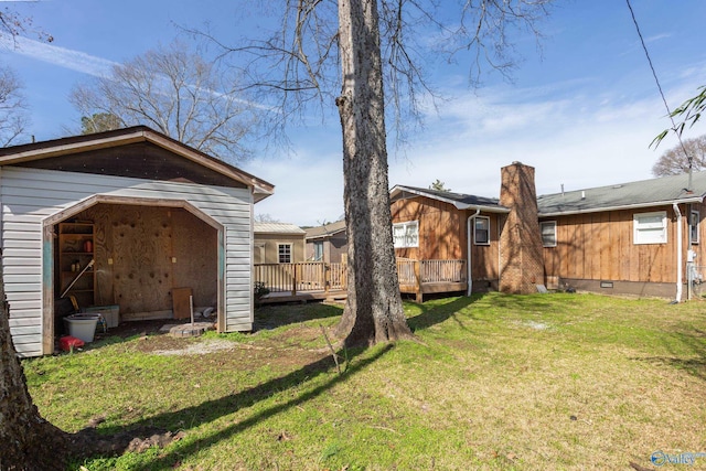 back of property with a deck and a lawn