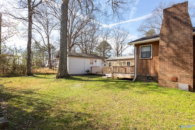 view of yard featuring a deck and a storage unit