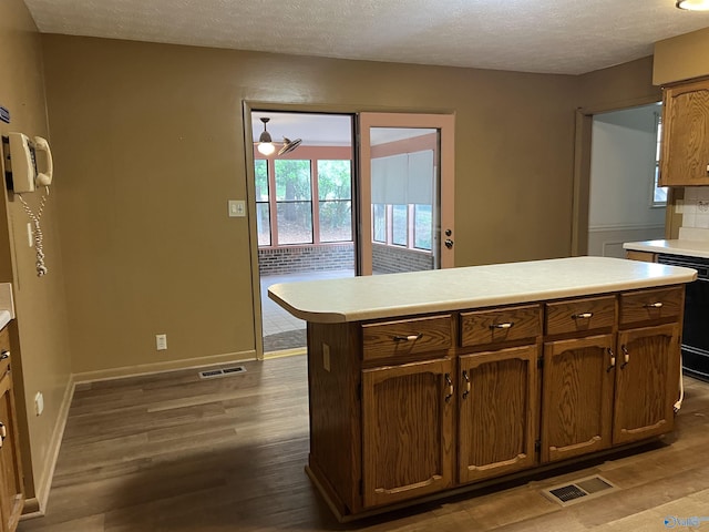 kitchen featuring light countertops, dark wood finished floors, visible vents, and a textured ceiling