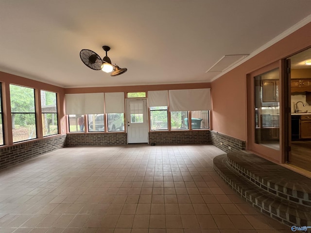 unfurnished sunroom featuring a sink and a healthy amount of sunlight