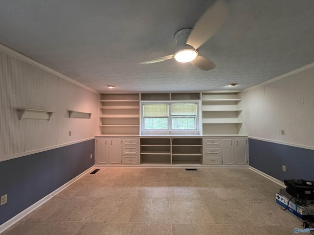 unfurnished office featuring visible vents, baseboards, a ceiling fan, and ornamental molding