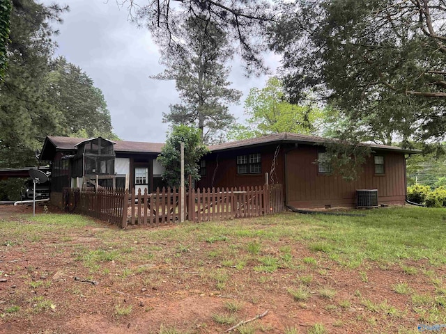 back of property with central AC unit, crawl space, and fence