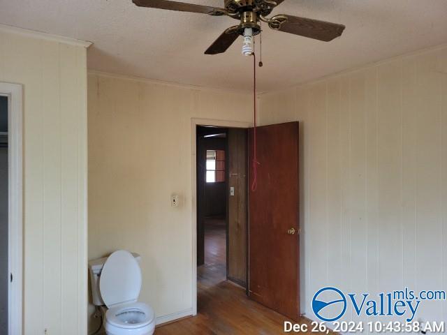 bathroom with ceiling fan, toilet, and wood-type flooring