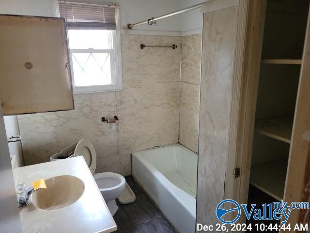 full bathroom featuring vanity, toilet, and tiled shower / bath