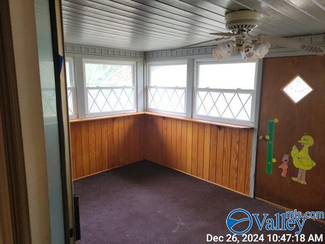 unfurnished sunroom featuring ceiling fan