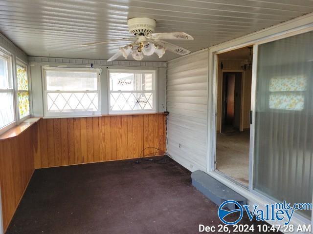 unfurnished sunroom featuring ceiling fan