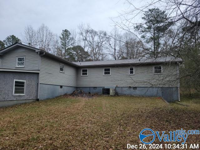 rear view of property with a yard and central AC unit