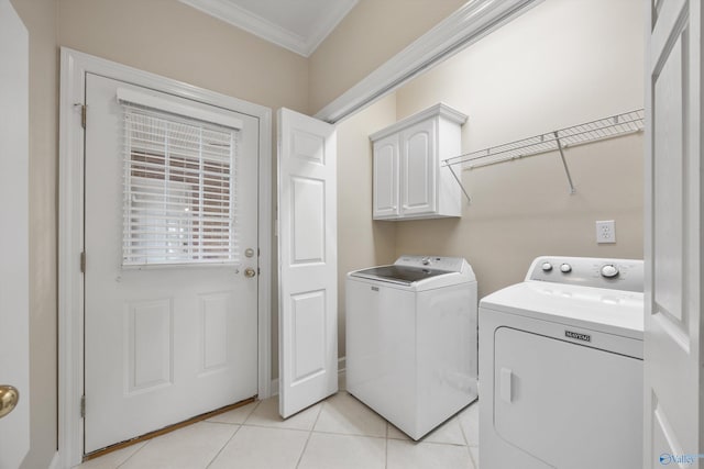 laundry room featuring cabinets, ornamental molding, light tile patterned floors, and washer and clothes dryer