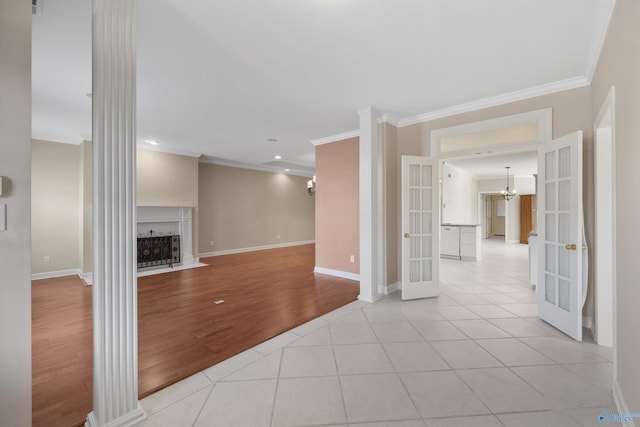 unfurnished living room featuring french doors, ornamental molding, and light tile patterned floors