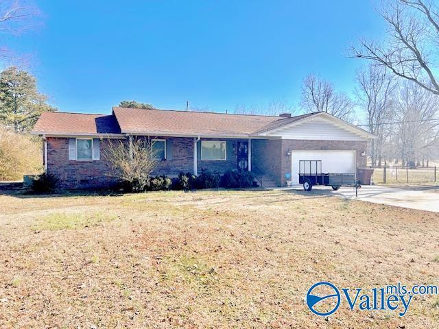 ranch-style home featuring a garage, a front yard, concrete driveway, and brick siding