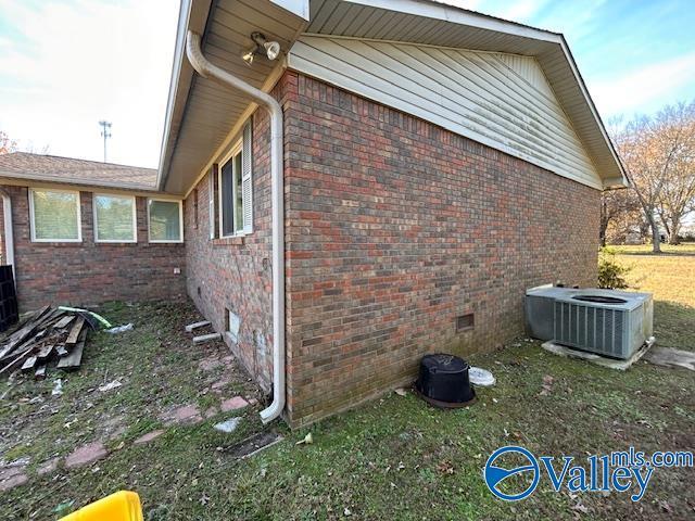 view of home's exterior featuring crawl space, brick siding, and central air condition unit