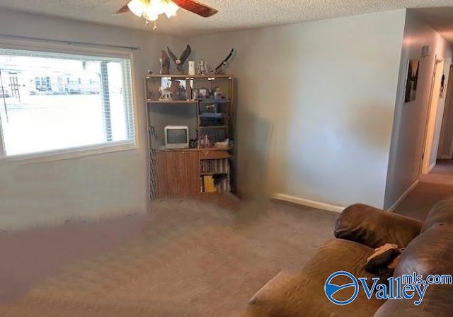 interior space with ceiling fan, a textured ceiling, and carpet flooring