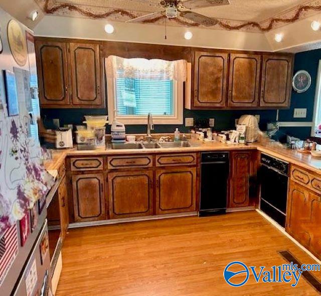 kitchen featuring light countertops, a sink, a ceiling fan, and light wood-style floors