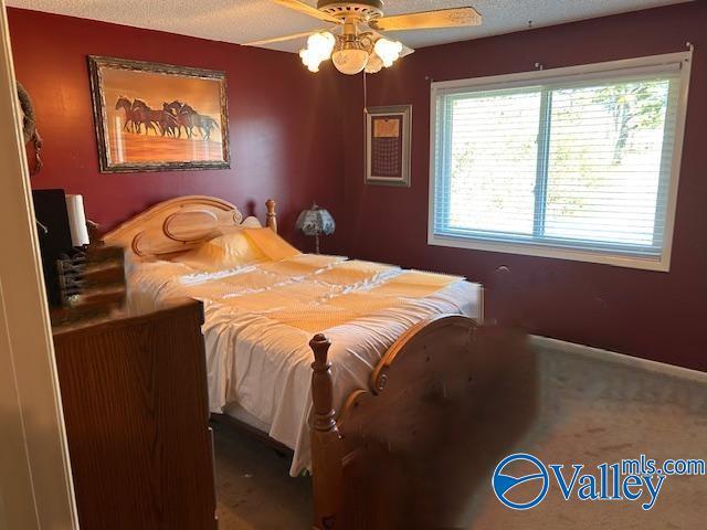 bedroom featuring ceiling fan and carpet