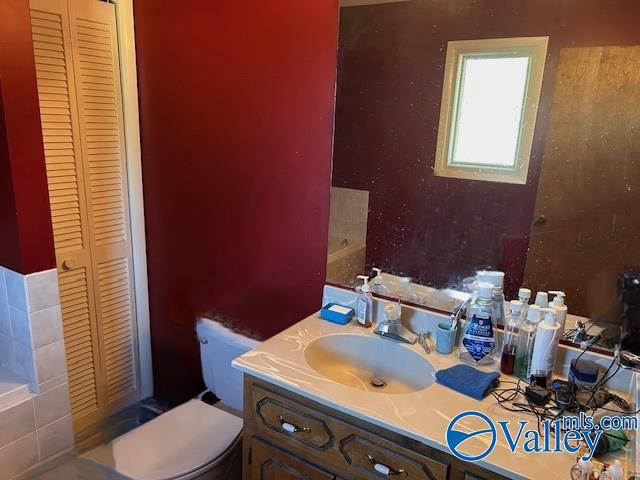 bathroom featuring a closet, vanity, and toilet