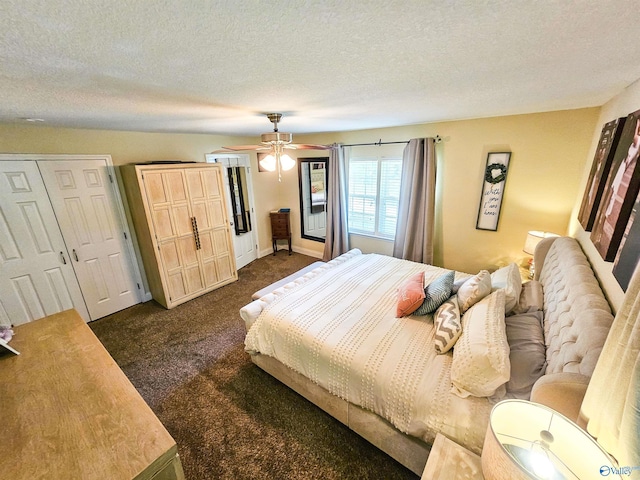 carpeted bedroom featuring ceiling fan, a textured ceiling, and two closets