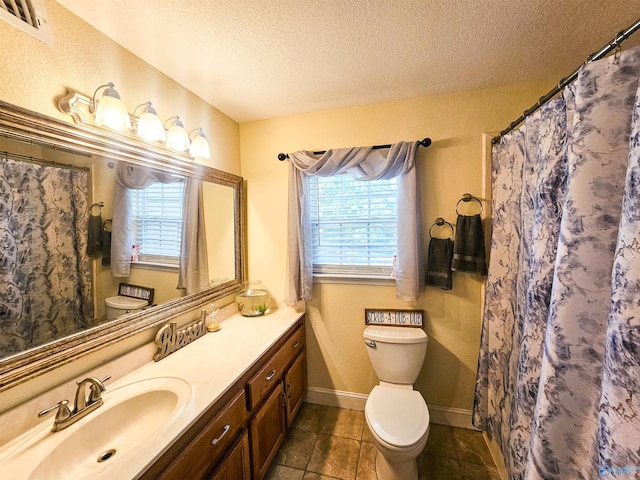 bathroom with vanity, a wealth of natural light, a textured ceiling, and toilet