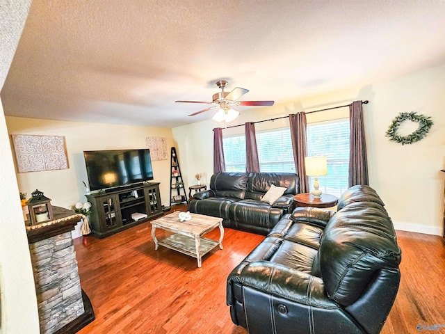 living room with hardwood / wood-style floors, a textured ceiling, and ceiling fan