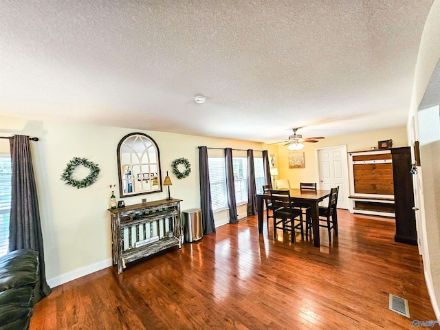 dining space with hardwood / wood-style flooring, ceiling fan, and a textured ceiling