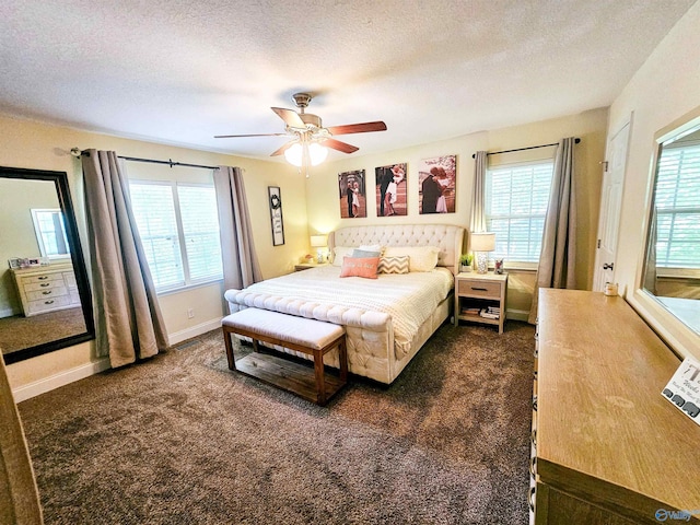 bedroom featuring multiple windows, ceiling fan, a textured ceiling, and dark colored carpet