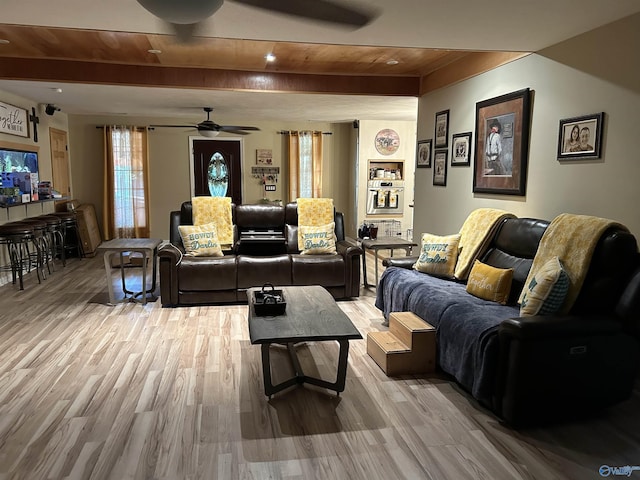 living room featuring beam ceiling, ceiling fan, and light wood-type flooring