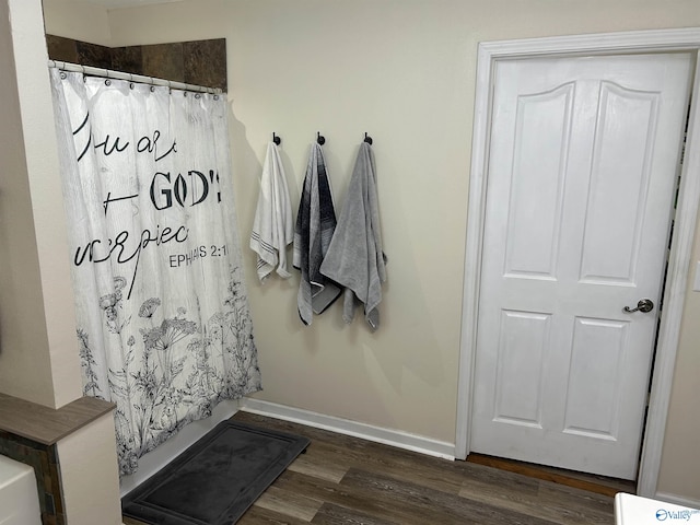 bathroom with hardwood / wood-style flooring and a shower with shower curtain