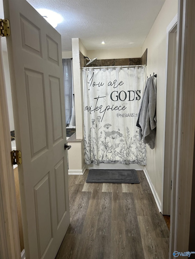 bathroom with shower / bathtub combination with curtain, hardwood / wood-style floors, and a textured ceiling